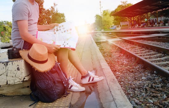 jeune femme attendant le train avec sac à dos